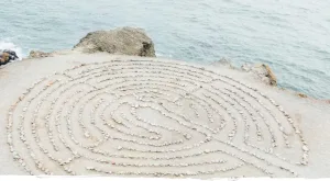 Hintergrundbild mit Labyrinth aus Steinen auf Sand